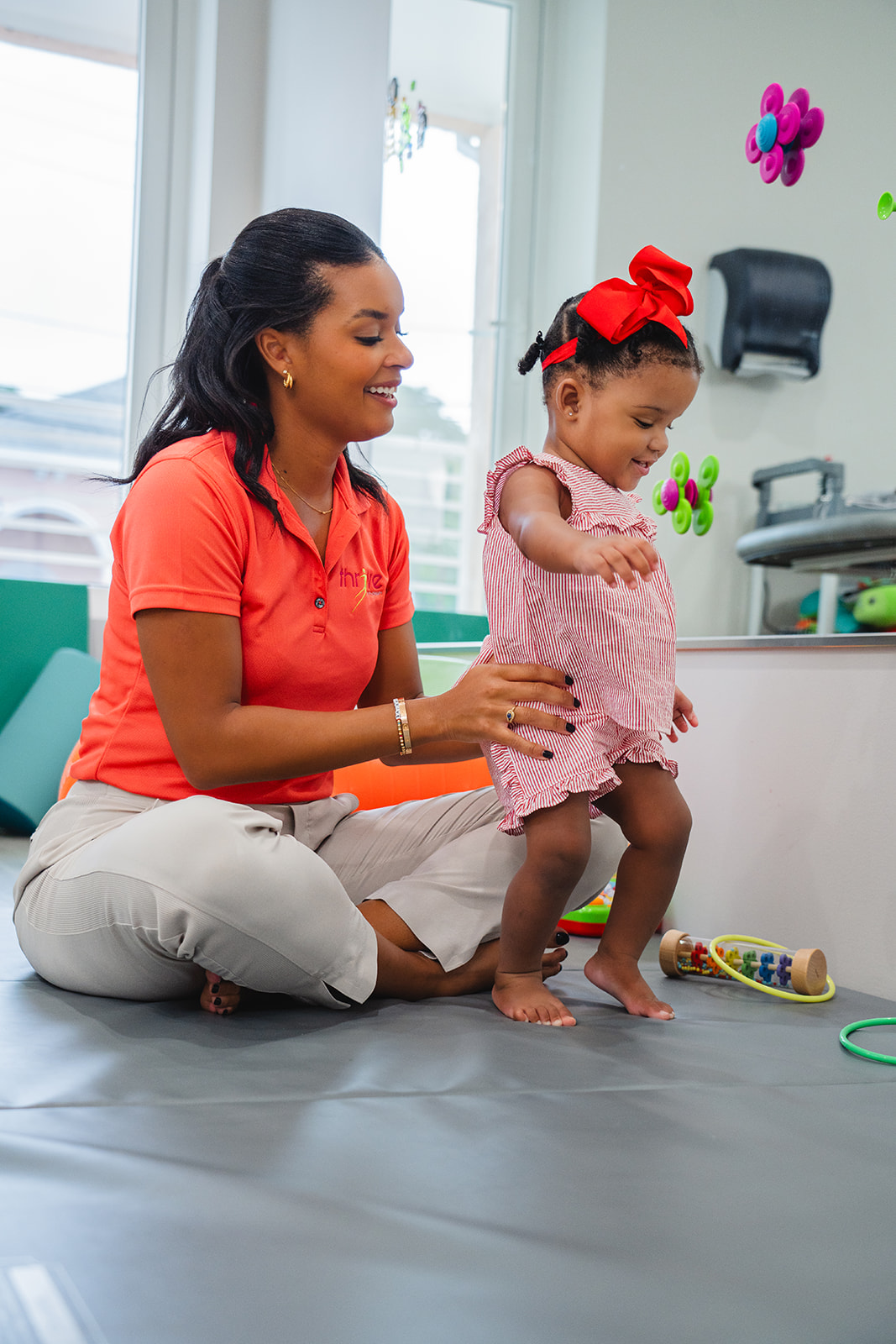 A Thrive therapist helping a toddler practice standing and walking